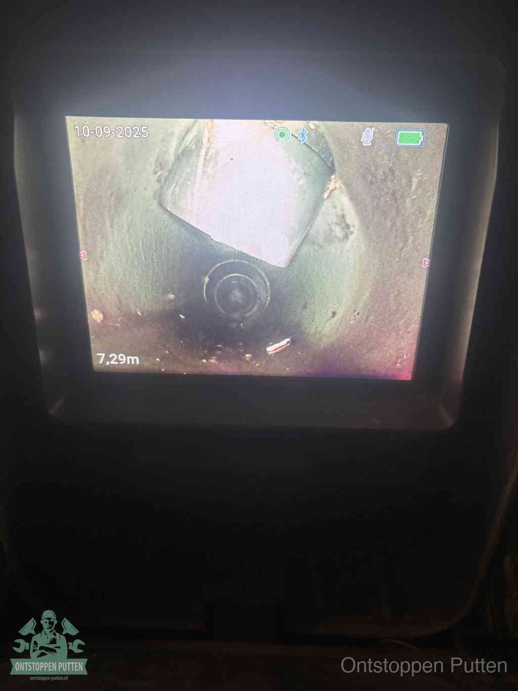 Het scherm van een rioolinspectiecamera toont de binnenkant van de leiding, eerst vaststellen waar de verstopping zit in Putten