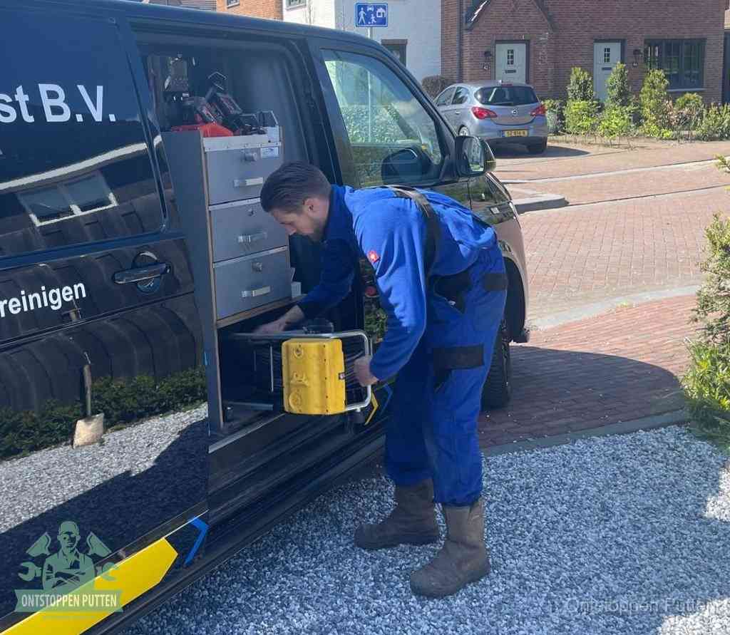 Een monteur pakt gereedschap uit de bedrijfsbus, het moment om een professionele ontstoppingsdienst in te schakelen in Putten