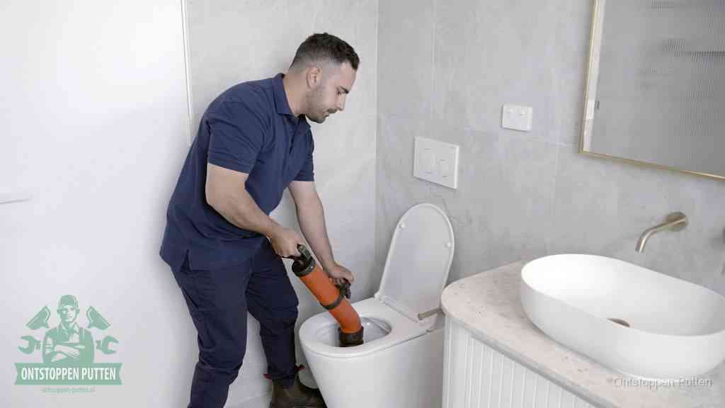 Een wc wordt met een handmatige ontstopper losgepompt, een verstopt toilet zelf ontstoppen met huismiddelen in Putten