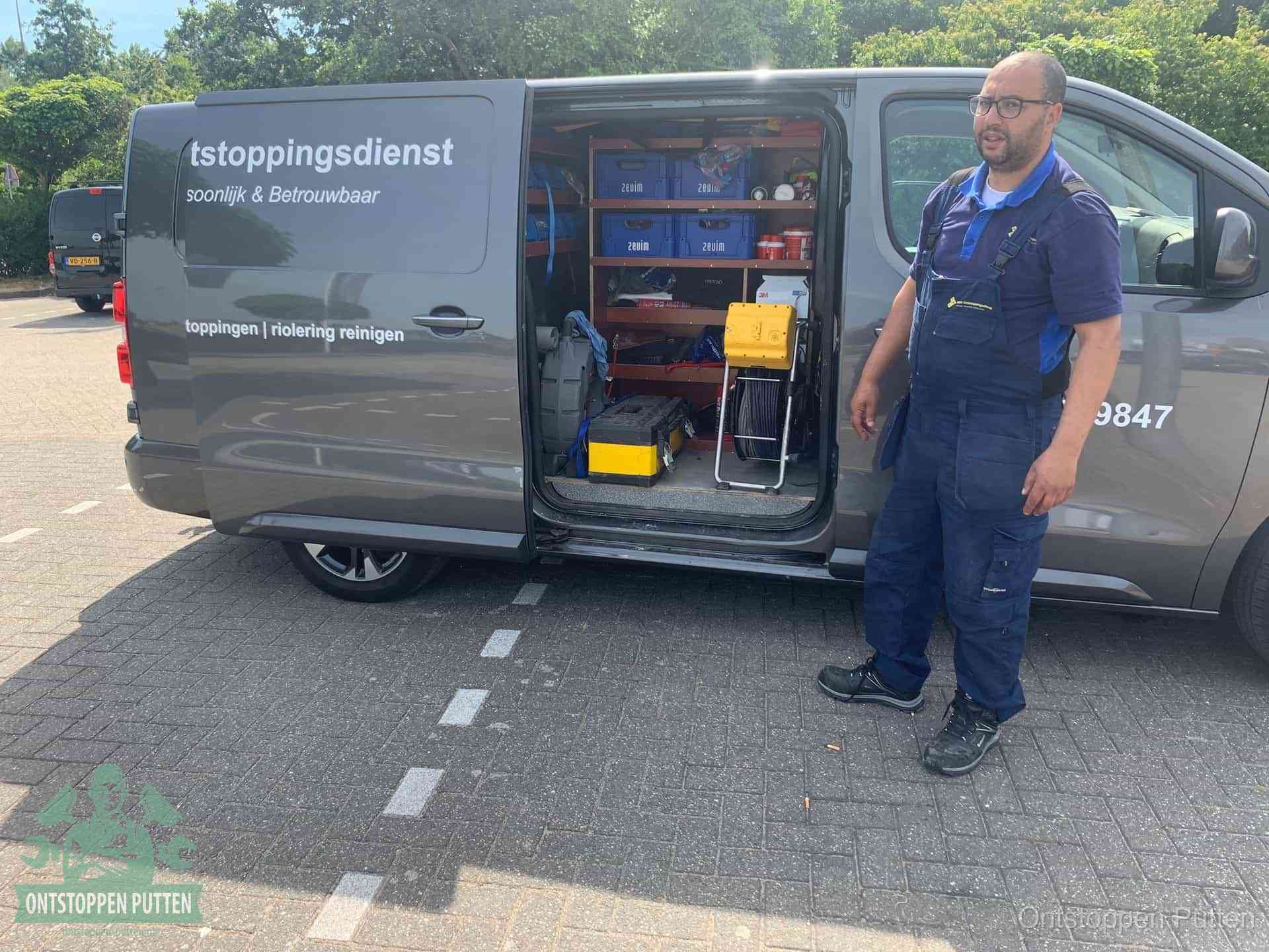 Een monteur staat klaar bij zijn bedrijfsbus met gereedschap, de vaste werkwijze van de ontstoppingsdienst in Putten
